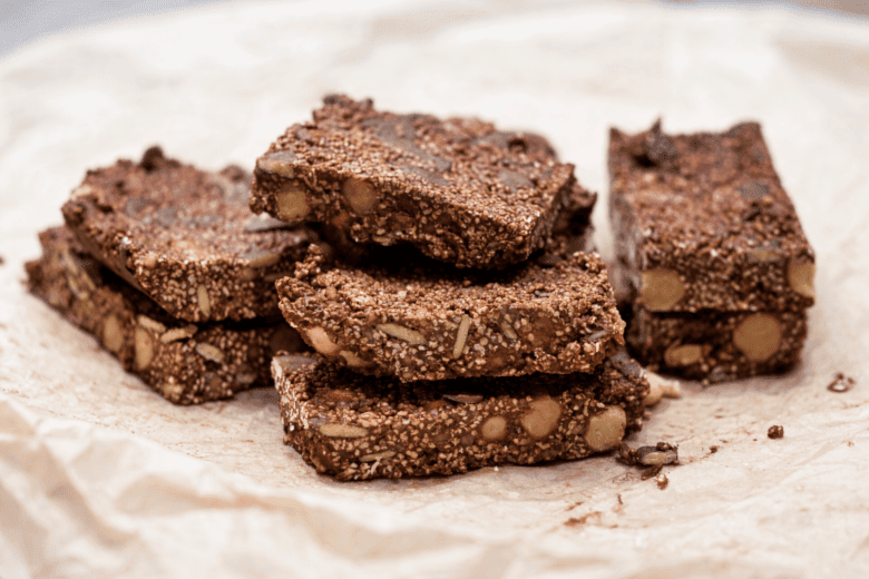 Zuckerfreier Proteinriegel mit Nüssen und Samen, auf Papier gelegt.