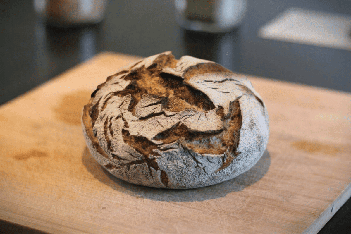 Rustikales Sauerteigbrot auf Holzbrett mit knuspriger Kruste.