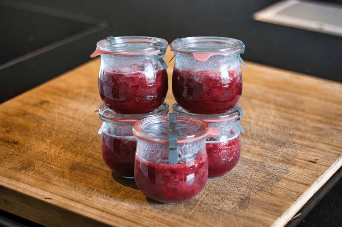 Selbstgemachte Erdbeermarmelade in Gläsern auf Holzbrett.