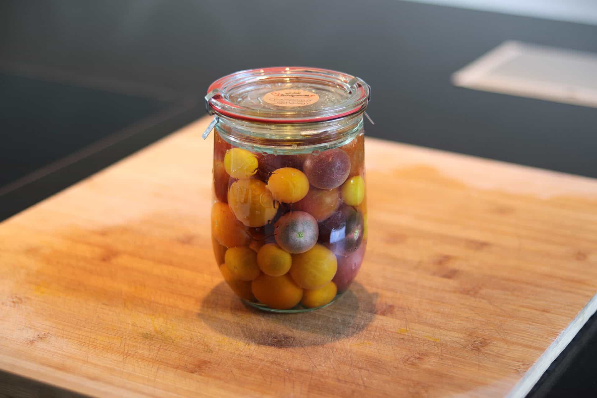 Fermentierte Weintrauben in einem Glas auf Holzbrett.