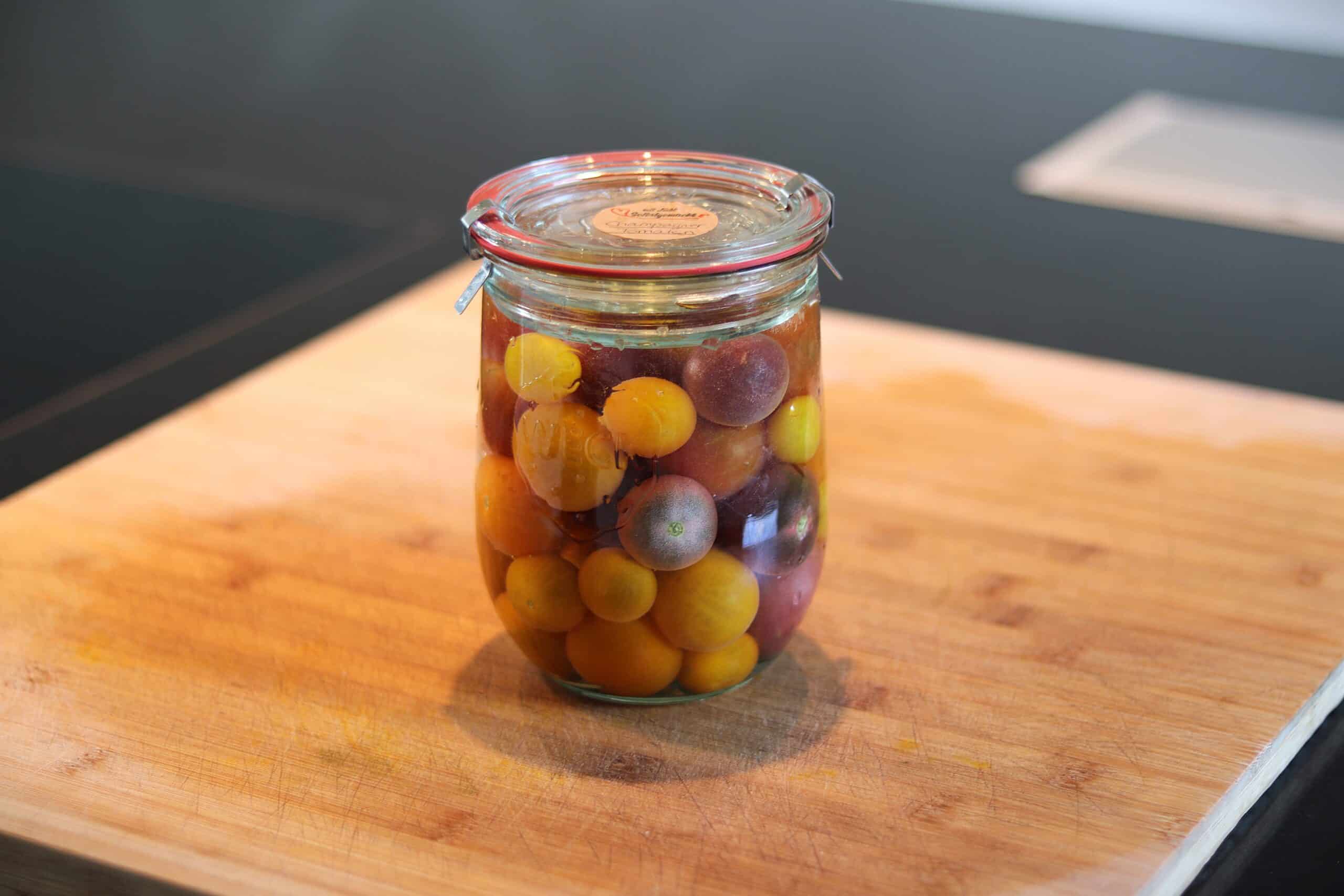 Fermentierte Weintrauben in einem Glas auf Holzbrett.