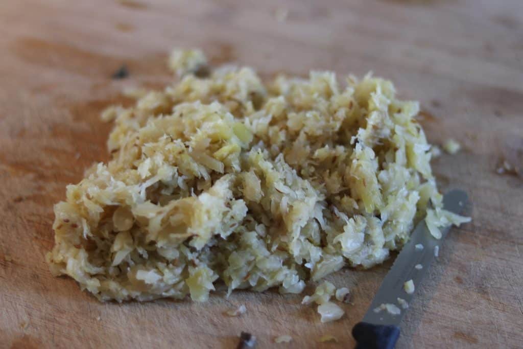 Frische Kartoffelmasse auf einem Holzbrett mit Messer.