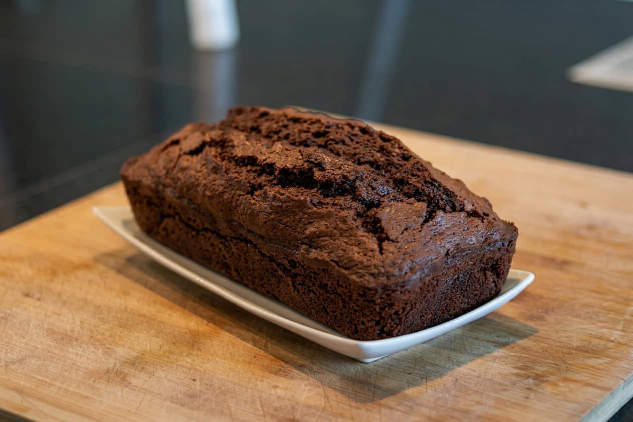 Dunkler, saftiger Kaffee-Kraut-Kuchen auf Holzbrett.