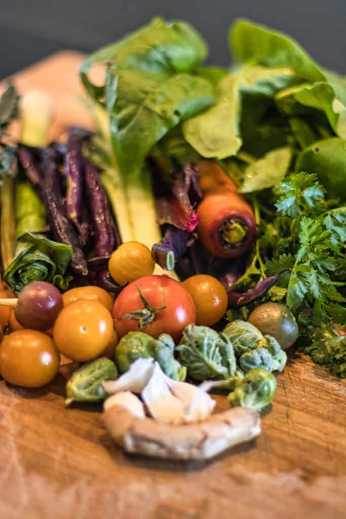 Vielfältiges frisches Gemüse auf einem Holzbrett, ideal für herbstliche Rezepte.